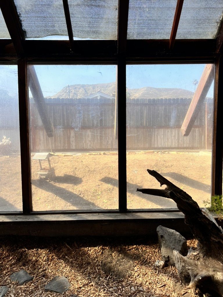 Mountain view seen through dirty greenhouse glass panes