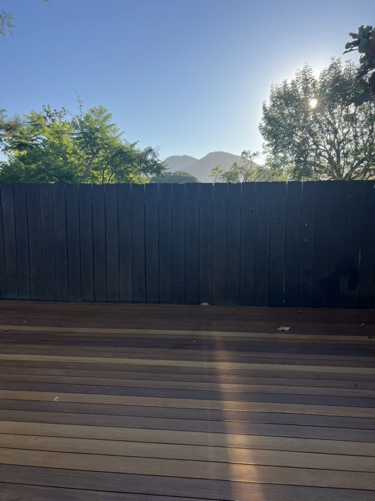 Black fence boards with warm Cumaru hardwood deck overlooking the mountains