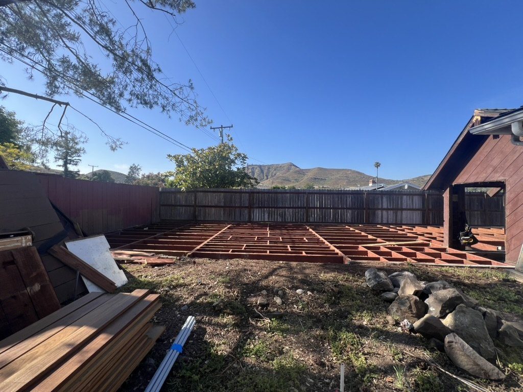 Deck framing with joists level to the house and stacked Cumaru hardwood lumber